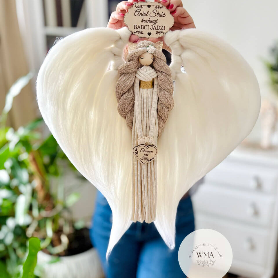 Duża personalizowana dekoracja ścienna Anioł Stróż kochanej Babci z makramy - figurka aniołka z długimi beżowymi włosami z białą różyczką i złotym paskiem w kremowej sukni z frędzli z drewnianym sercem z napisem Czuwam nad Tobą, ogromne białe skrzydła w kształcie serca, drewniana tabliczka z imieniem, wyjątkowy prezent dla babci na Dzień Babci lub urodziny, handmade