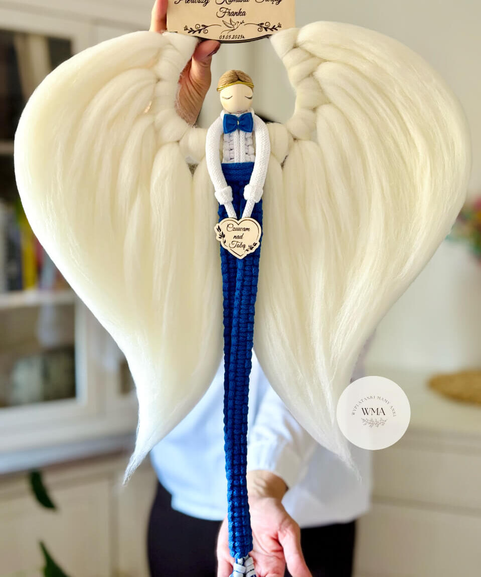 Duża personalizowana dekoracja ścienna Anioł Stróż na Pierwszą Komunię Świętą chłopca z makramy - figurka aniołka z blond włosami w granatowym stroju z muszką i miniaturowymi trampkami z drewnianym sercem z napisem Czuwam nad Tobą, ogromne białe skrzydła w kształcie serca, drewniana tabliczka z imieniem i datą komunii, handmade