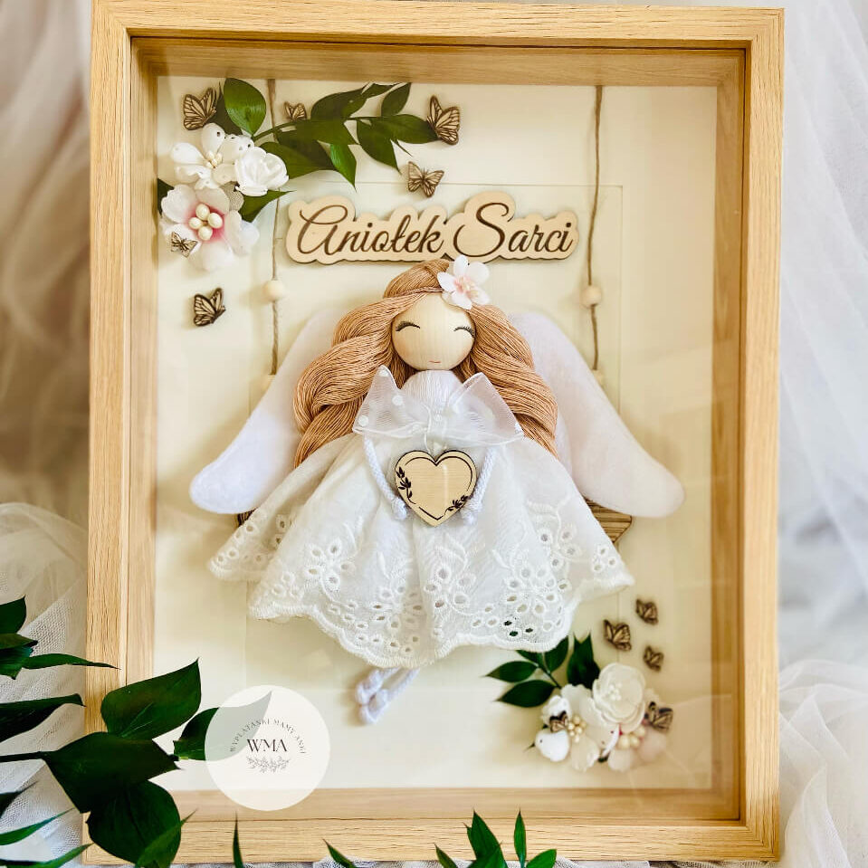 Personalizowana ramka w naturalnej drewnianej ramie z figurką aniołka z makramy z rudymi włosami w białej koronkowej sukience z materiałowymi skrzydłami trzymającego drewniane serce, drewniana tabliczka z napisem Aniołek Sarci, dekoracja z białych kwiatów drewnianych motyli i zielonych gałązek, wyjątkowy prezent dla dziecka lub na chrzest, handmade