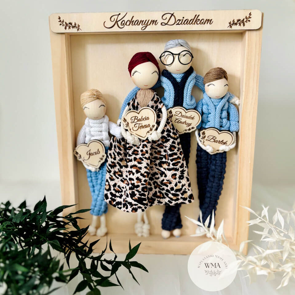 Personalizowana ramka w sosnowej ramie z napisem Kochanym Dziadkom z czterema figurkami rodziny z makramy - babcia w bordowej czapce w sukience w panterkę trzymająca niemowlę, dziadek w okularach z siwymi włosami w błękitnym swetrze, dwoje wnuków w błękitnych i granatowych strojach z drewnianymi sercami z imionami, wyjątkowy prezent dla dziadków, handmade