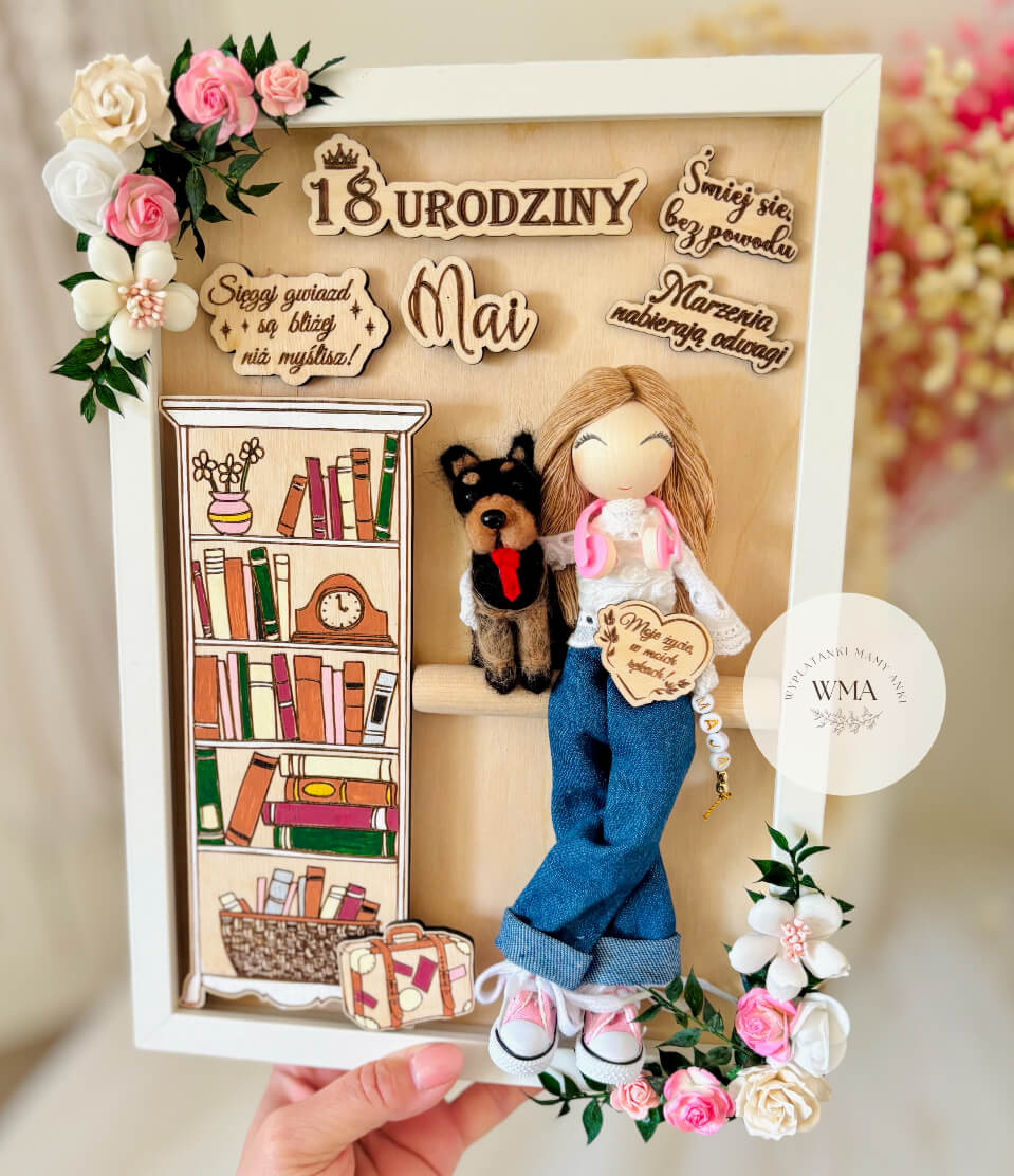 Personalizowana drewniana ramka urodzinowa z ręcznie robioną laleczką w dżinsach z psem, drewnianymi dekoracjami z motywem ksiąg i walizki, otoczona różowymi i białymi kwiatami, wyjątkowy prezent na osiemnastkę