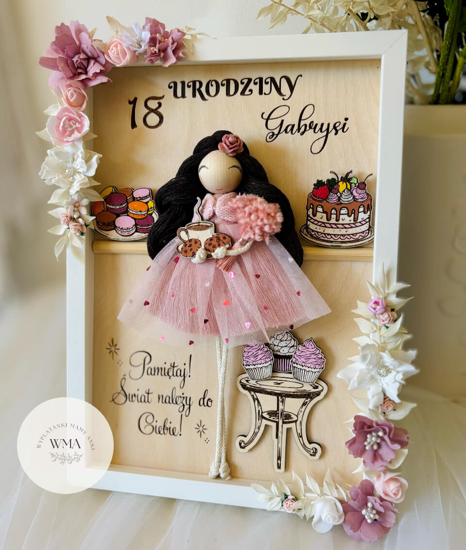 Personalizowana drewniana ramka na osiemnastkę z ręcznie robioną laleczką z czarnymi włosami w różowej tiulowej sukience trzymającą kawę i bukiet, drewniane ilustracje tortów i makaroników, różowo-biała dekoracja kwiatowa, oryginalny prezent urodzinowy