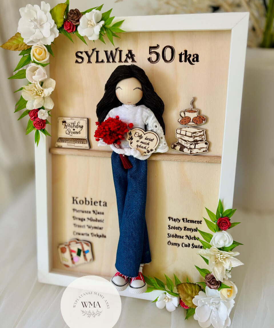 Personalizowana drewniana ramka na pięćdziesiątkę z ręcznie robioną laleczką z czarnymi włosami w dżinsach i białej bluzce trzymającą czerwony bukiet, drewniane elementy z laptopem i książkami, biało-czerwona dekoracja kwiatowa, wyjątkowy prezent na okrągłe urodziny
