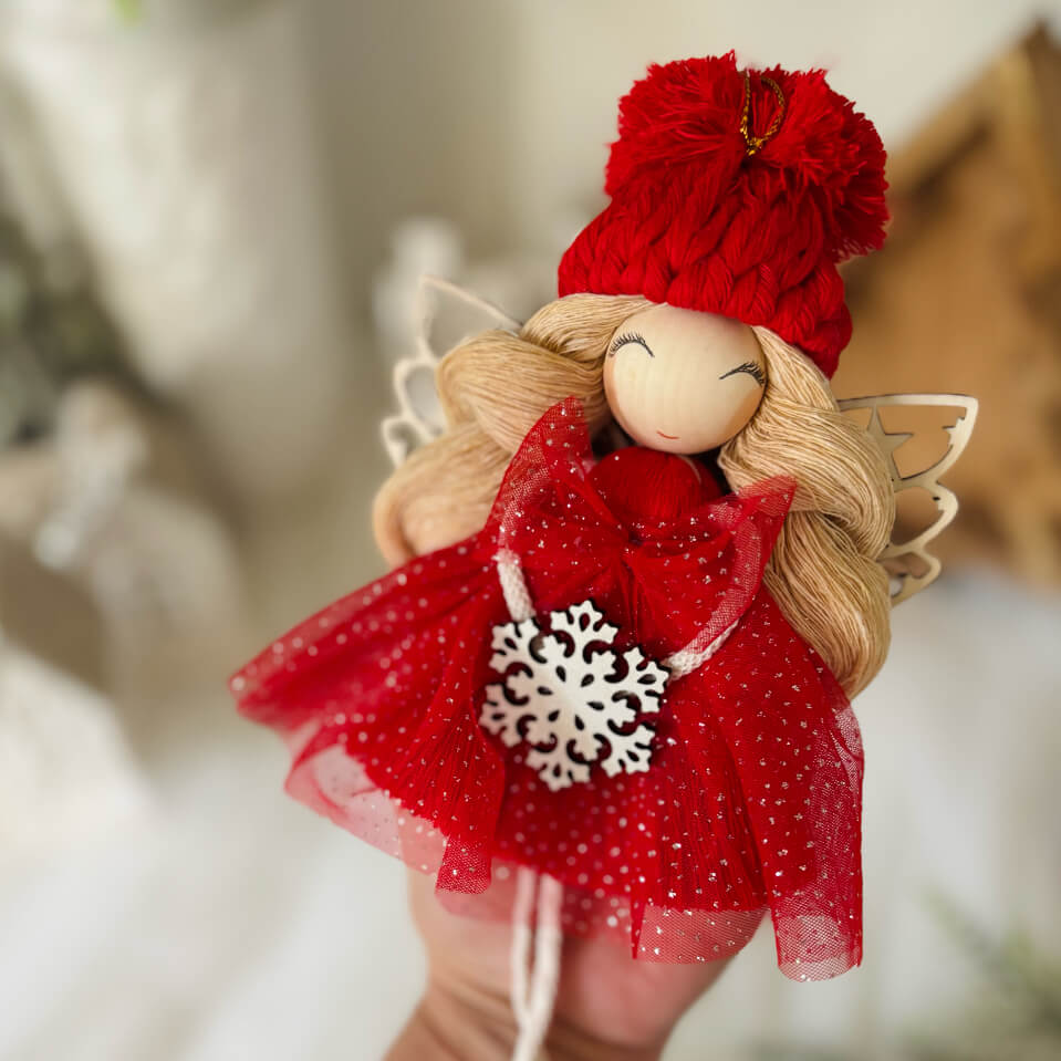 Czerwony aniołek z makramy z blond włosami i białym drewnianym płatkiem śniegu w brokatowej sukience - ozdoba świąteczna handmade WMA
