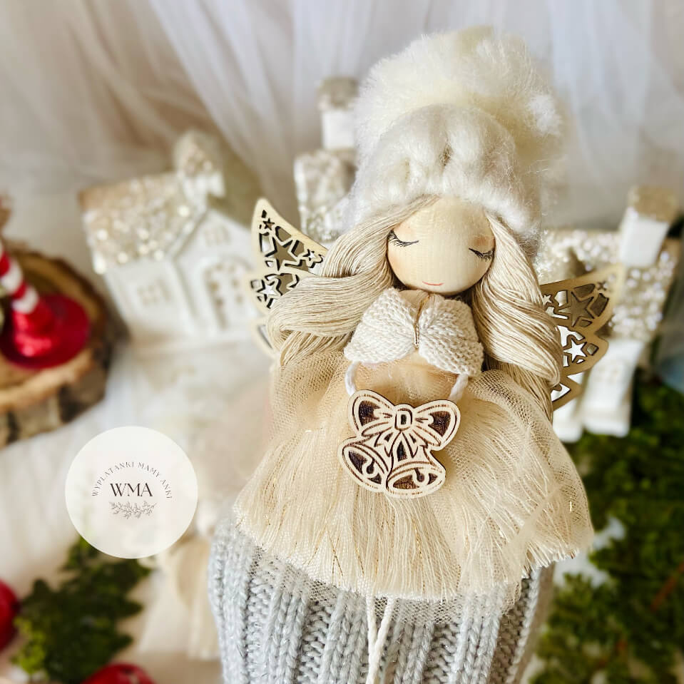 Kremowy aniołek z makramy z ażurowymi drewnianymi skrzydłami i dzwonkami - elegancka ozdoba świąteczna handmade WMA