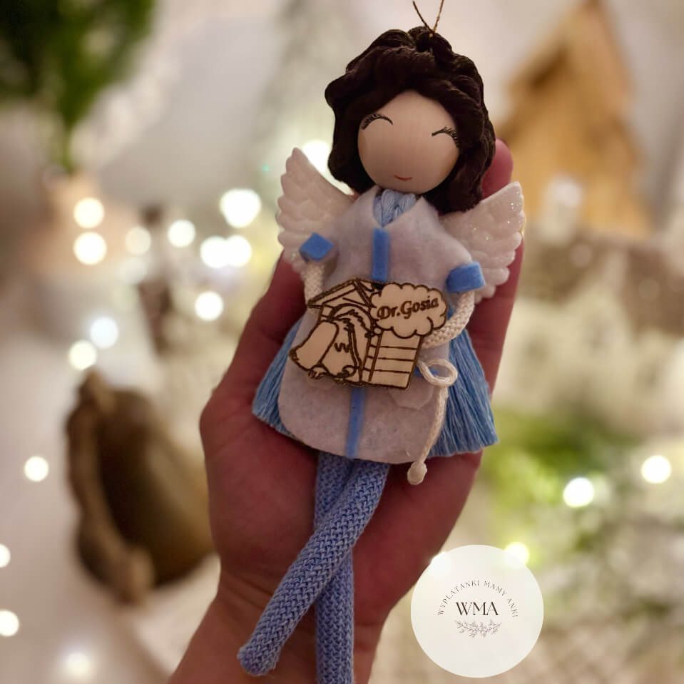 Niebieski aniołek z makramy w fartuchu lekarskim z personalizowaną drewnianą zawieszką z imieniem Dr. Gosia – wyjątkowy handmade prezent dla lekarza WMA