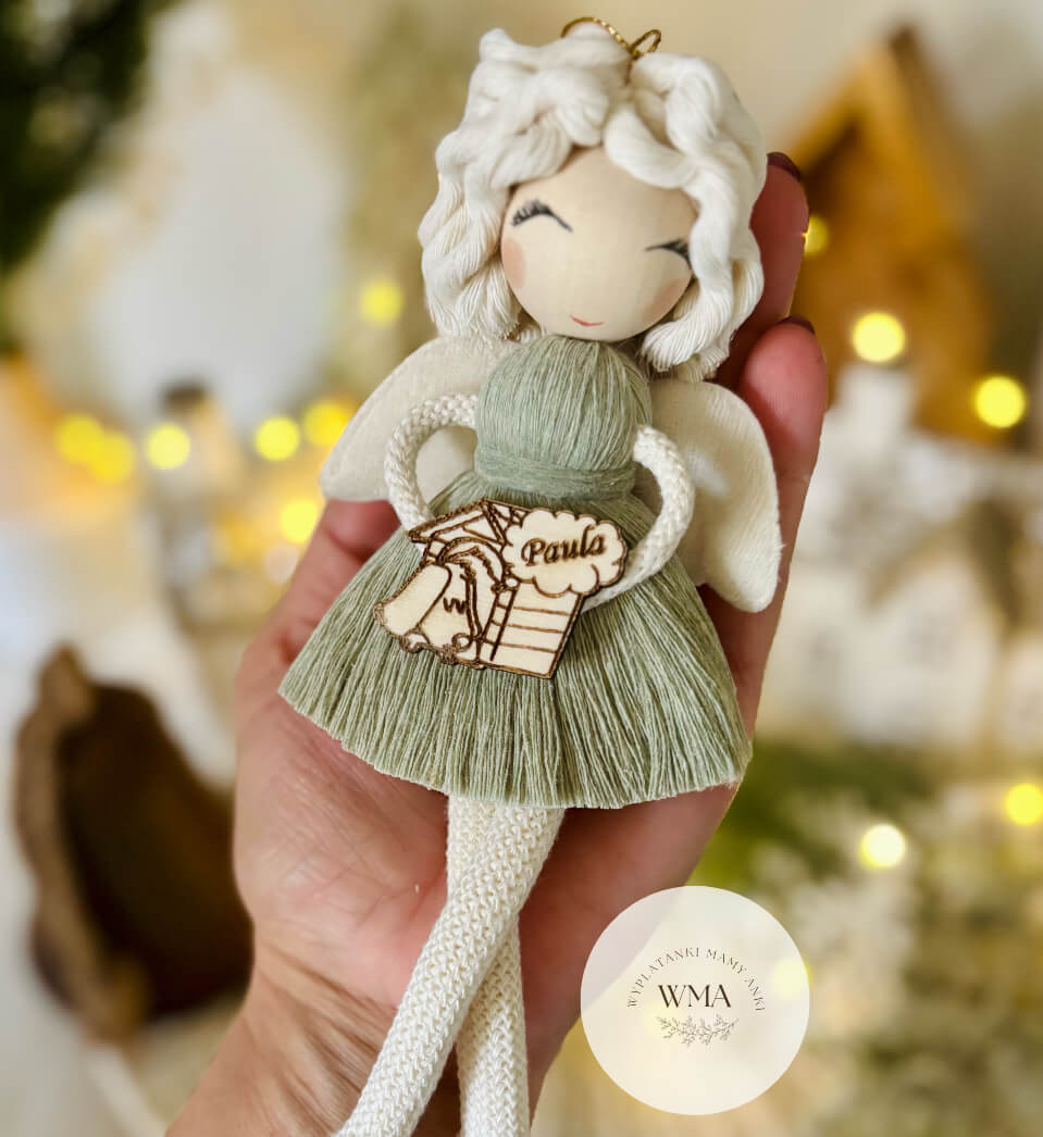 Szałwiowy aniołek z makramy z kręconymi białymi włosami, trzymający personalizowaną drewnianą zawieszką z pieskiem i imieniem - handmade prezent dla miłośnika psów WMA