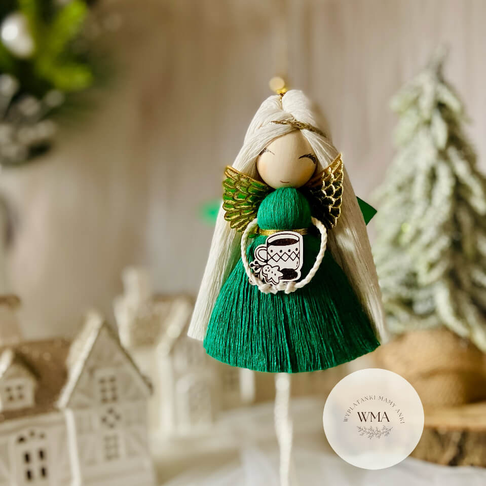 Zielony aniołek z makramy z białymi włosami i złotymi skrzydłami, trzymający zawieszką z kubkiem gorącego napoju - handmade ozdoba świąteczna WMA
